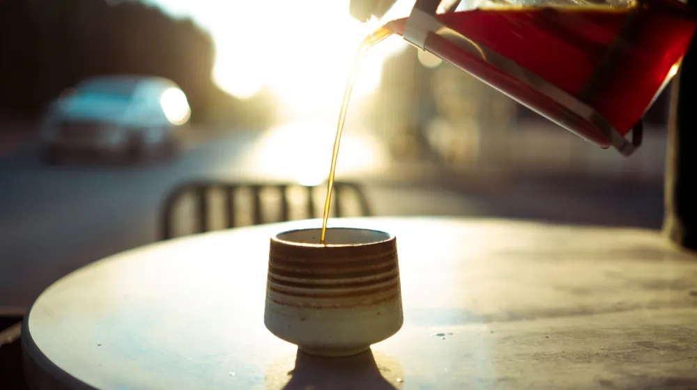 Taza de café junto a una ventana al amanecer